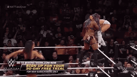 a wrestling match is taking place in a ring with a sign up for a 30 day free trial .