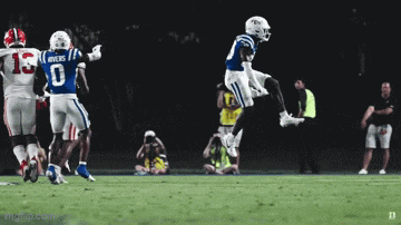 a football player wearing a jersey with the number 0 on it jumps in the air