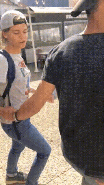a man and a woman are standing next to each other and the woman is wearing a white hat