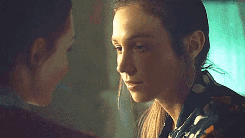 a close up of two women looking at each other in a room .