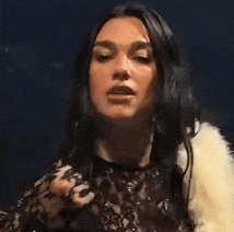 a woman with long dark hair is wearing a fur coat .