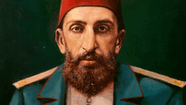 a man with a beard is wearing a red hat and a blue jacket