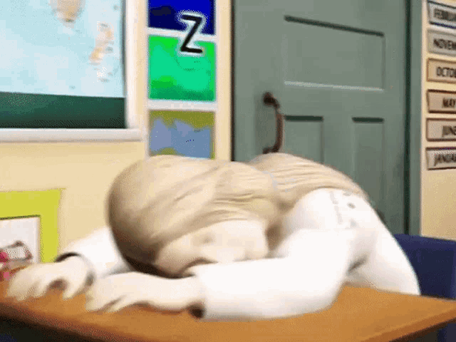 a cartoon character is sleeping on a desk in front of a bulletin board with the letter z on it