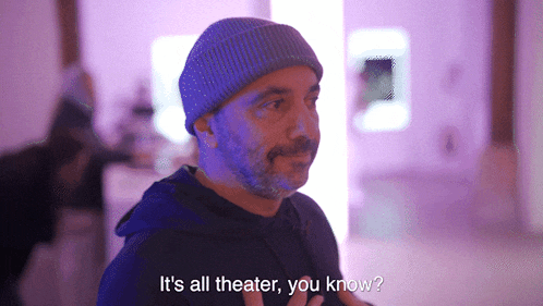 a man wearing a beanie and a black hoodie says it 's all theater you know