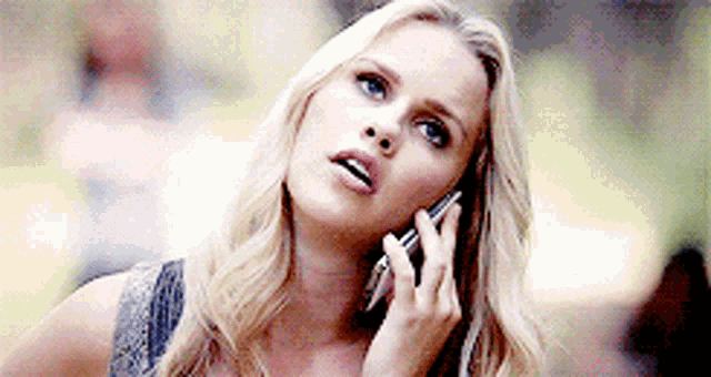 a woman is talking on a cell phone and looking up .