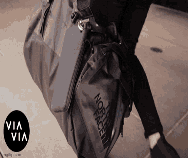a person is carrying a bag that says the north face