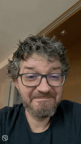 a man with glasses and a beard is wearing a black shirt that says whatsapp