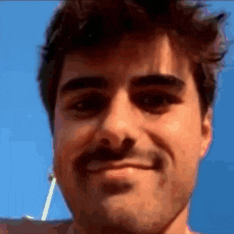 a man with a mustache is smiling and looking at the camera with a blue sky in the background .