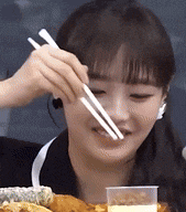 a woman is eating a meal with chopsticks and a glass of milk .