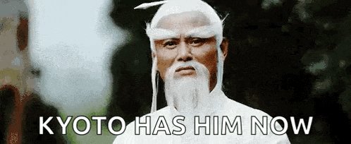 a man with a white beard and a white wig is standing in front of a tree and says kyoto has him now