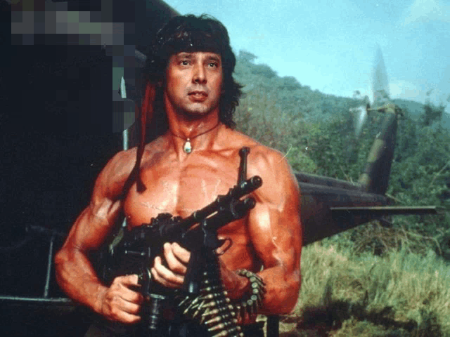 a shirtless man is holding a gun in a field