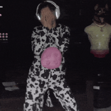 a person in a dalmatian costume holding a pink ball