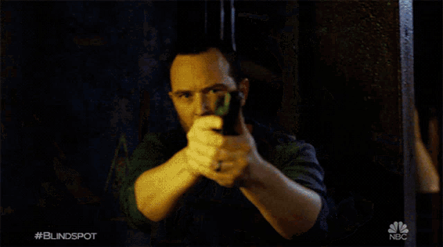 a man with a beard is holding a hammer with the nbc logo on the bottom right