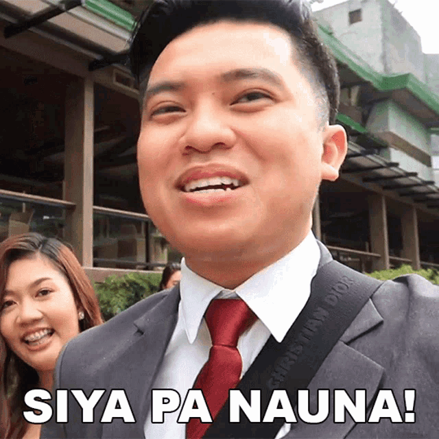 a man in a suit and tie is smiling with the words siya pa nauna behind him