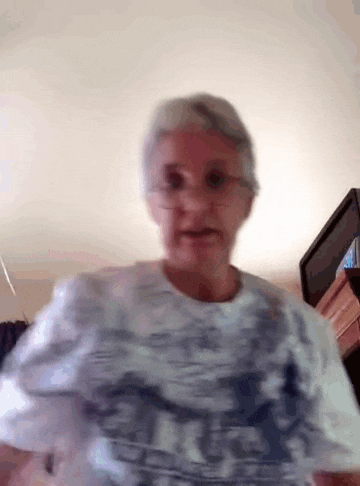 an elderly woman wearing glasses and a t-shirt that says ' i love you '