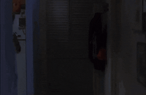 a woman in a bathrobe is standing in a dark room .