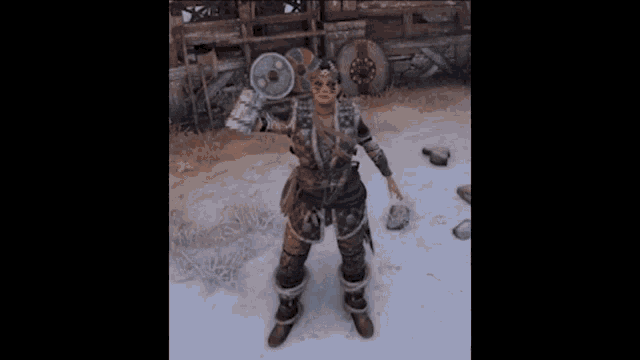 a woman in a viking costume is standing in the snow holding a hammer and shields .