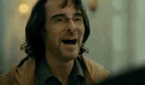 a close up of a man laughing with his mouth open in a joker movie .