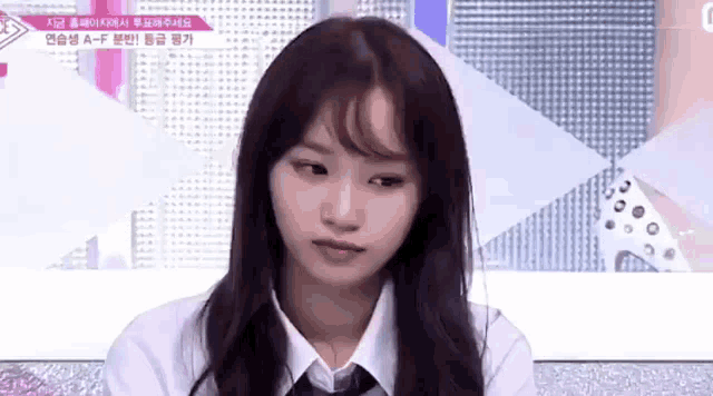 a girl in a white shirt and tie is making a face .