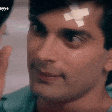a man with a bandage on his forehead is smiling