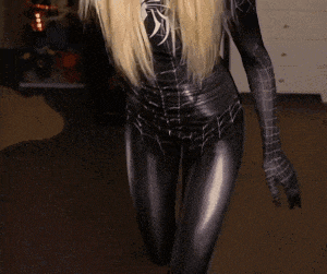 a woman in a black spiderman costume is crawling on the floor