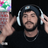 a man wearing headphones and a beanie has the date 17/25 on the bottom right