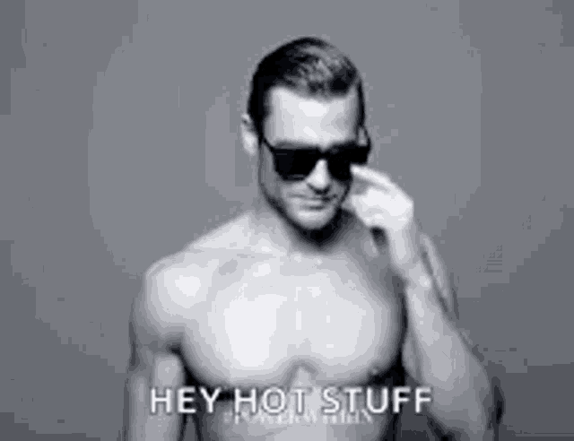 a shirtless man wearing sunglasses is standing in front of a white background .