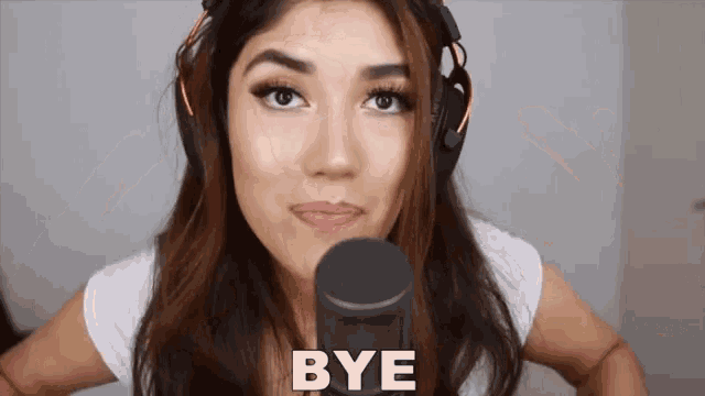 a woman wearing headphones is saying bye