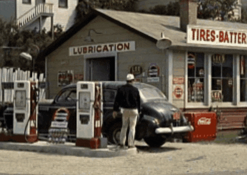 a man is standing in front of a lubrication shop