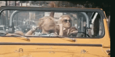 two people are sitting in a yellow jeep with the top down
