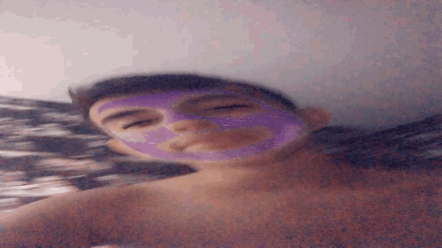 a woman is wearing a purple mask on her face