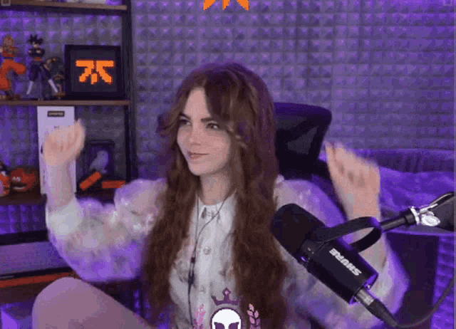 a girl with long hair is sitting in front of a shure microphone