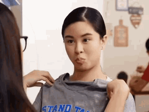 a woman is wearing a t-shirt that says stand tall .