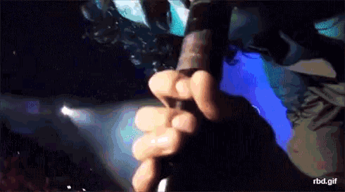 a close up of a person holding a microphone with the url rbd.gif below it