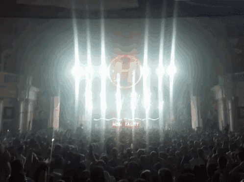 a crowd of people are watching a dj perform at a club