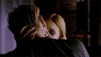 a man and a woman are kissing and hugging each other .