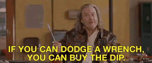 a man in a leather jacket is holding a wrench in his hand and talking .