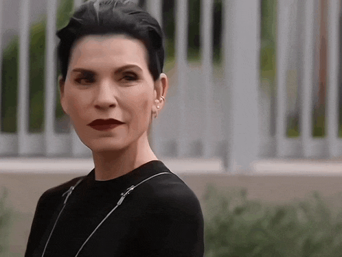 a woman with short black hair is wearing a black shirt