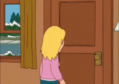 a woman in a pink shirt is standing in front of a door