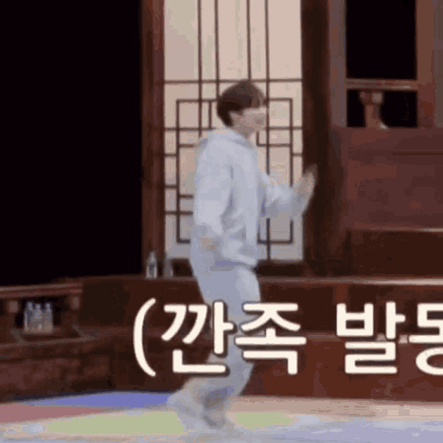 a man is dancing on a colorful floor in a room with korean writing .
