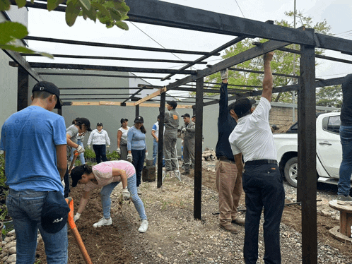 a group of people are working on a structure and one of the men is wearing a blue shirt that says o'neill on the back