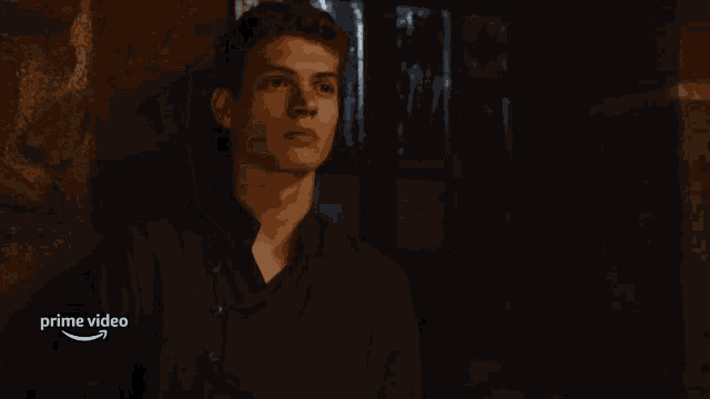 a man in a dark room with a prime video logo on the bottom