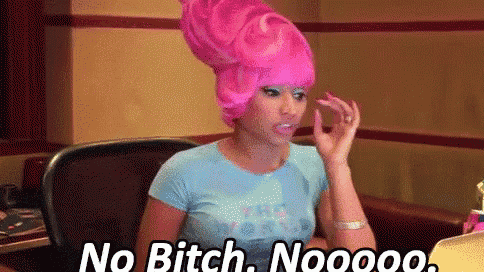 a woman in a pink wig is sitting at a desk and saying `` no bitch . nooooo . ''