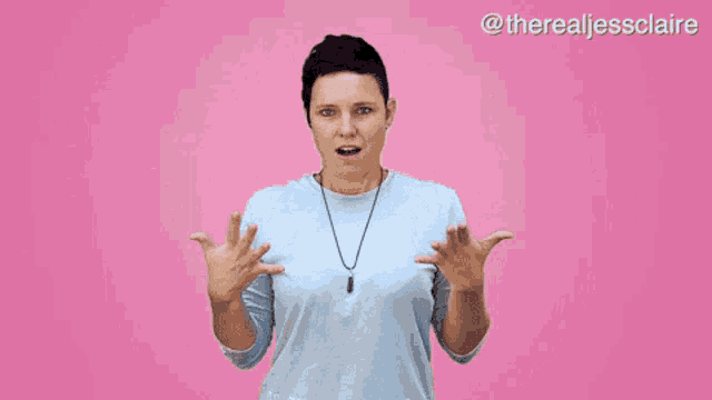 a woman with a surprised look on her face is standing in front of a pink background with the hashtag therealjessclaire