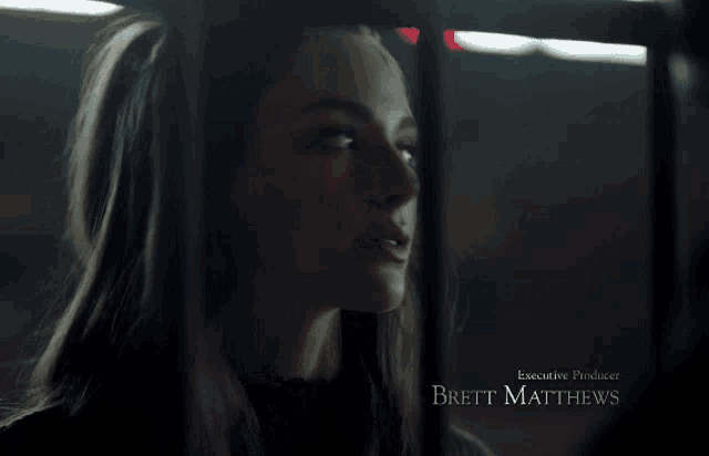 a close up of a woman behind bars with the name matthew on the bottom right