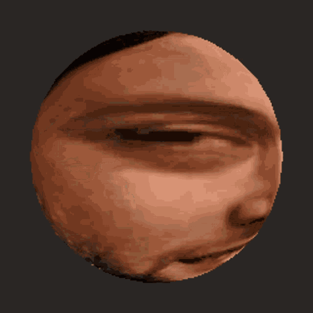 a close up of a man 's face in a circle on a dark background