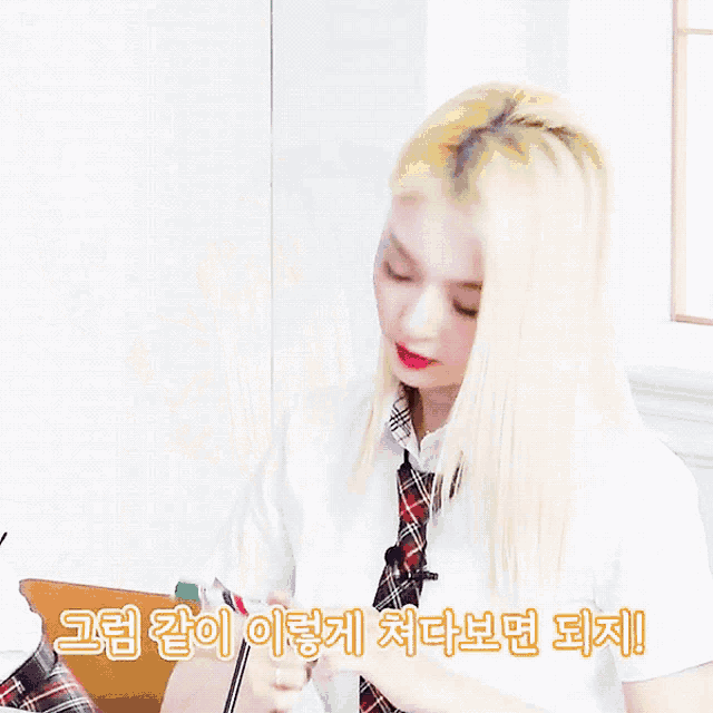 a woman with blonde hair is sitting with her hands on her face
