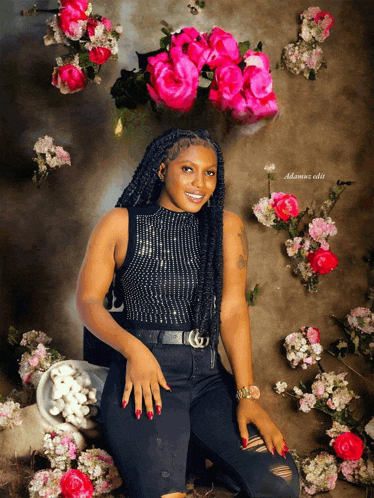 a woman is posing in front of a wall of pink flowers with the name adamue edit on the bottom right