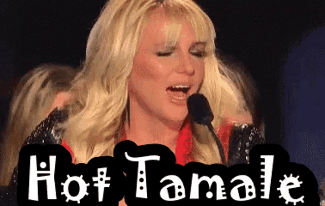 a woman singing into a microphone with the words hot tamale written below her