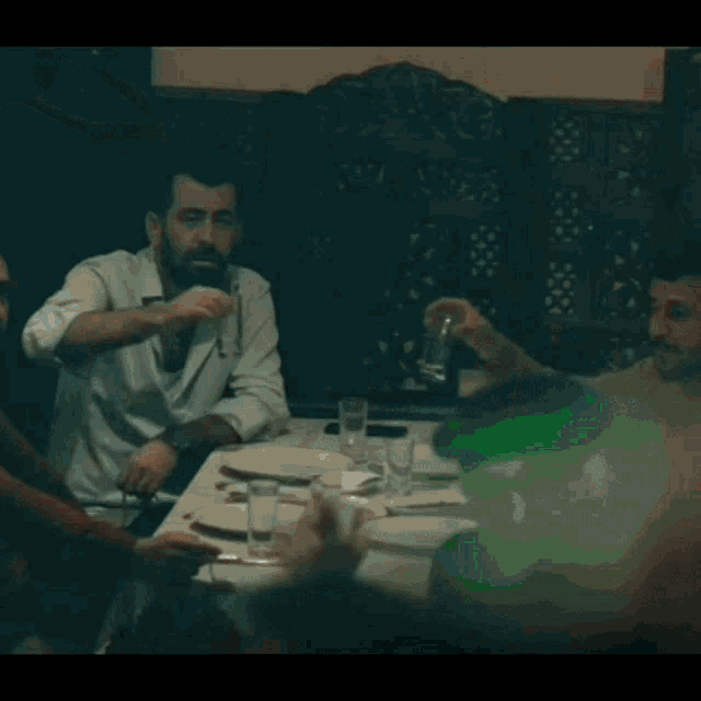 a group of people are sitting at tables in a restaurant watching a band perform